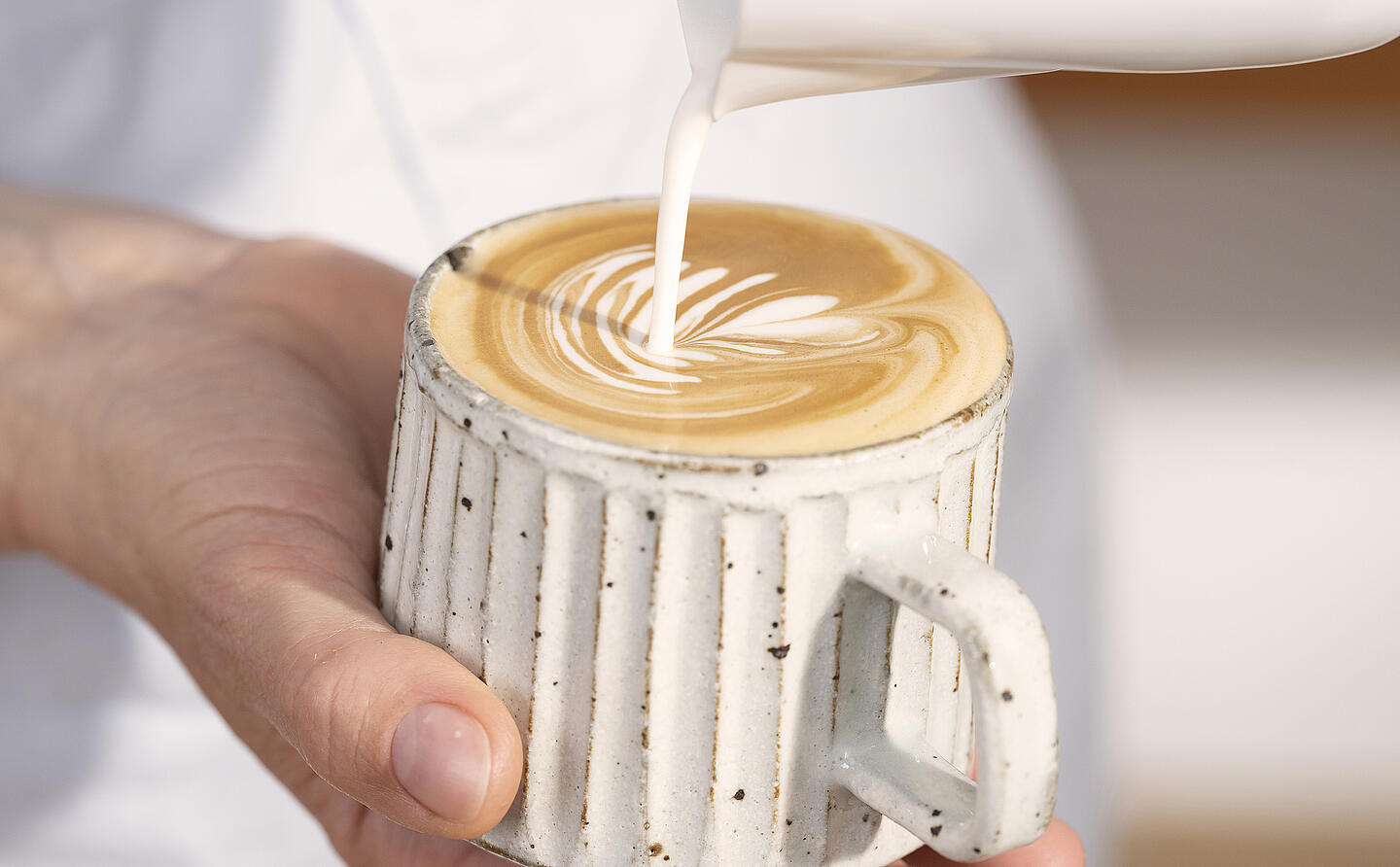 Barista odlewa serce Latte Art w filiżance Cappuccino