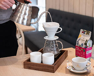 Zaměstnanec hotelu připravuje čerstvou filtrovanou kávu Dallmayr v dripperu
