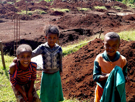 Trīs etiopiešu bērni pie jaunās skolas būvlaukuma