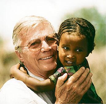 Karlheincs Bēms ar etiopiešu bērnu rokās